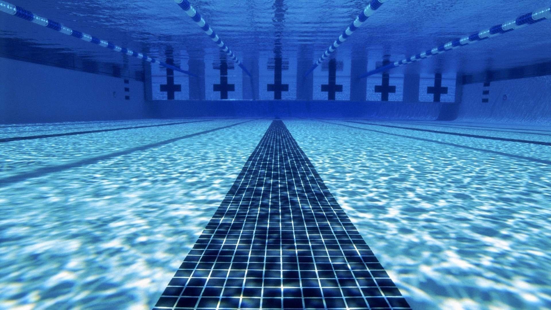 Pristine lap pool lanes with underwater light patterns on blue tile